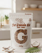 Granola packaging with 'The Granola Kid' branding on a kitchen counter.